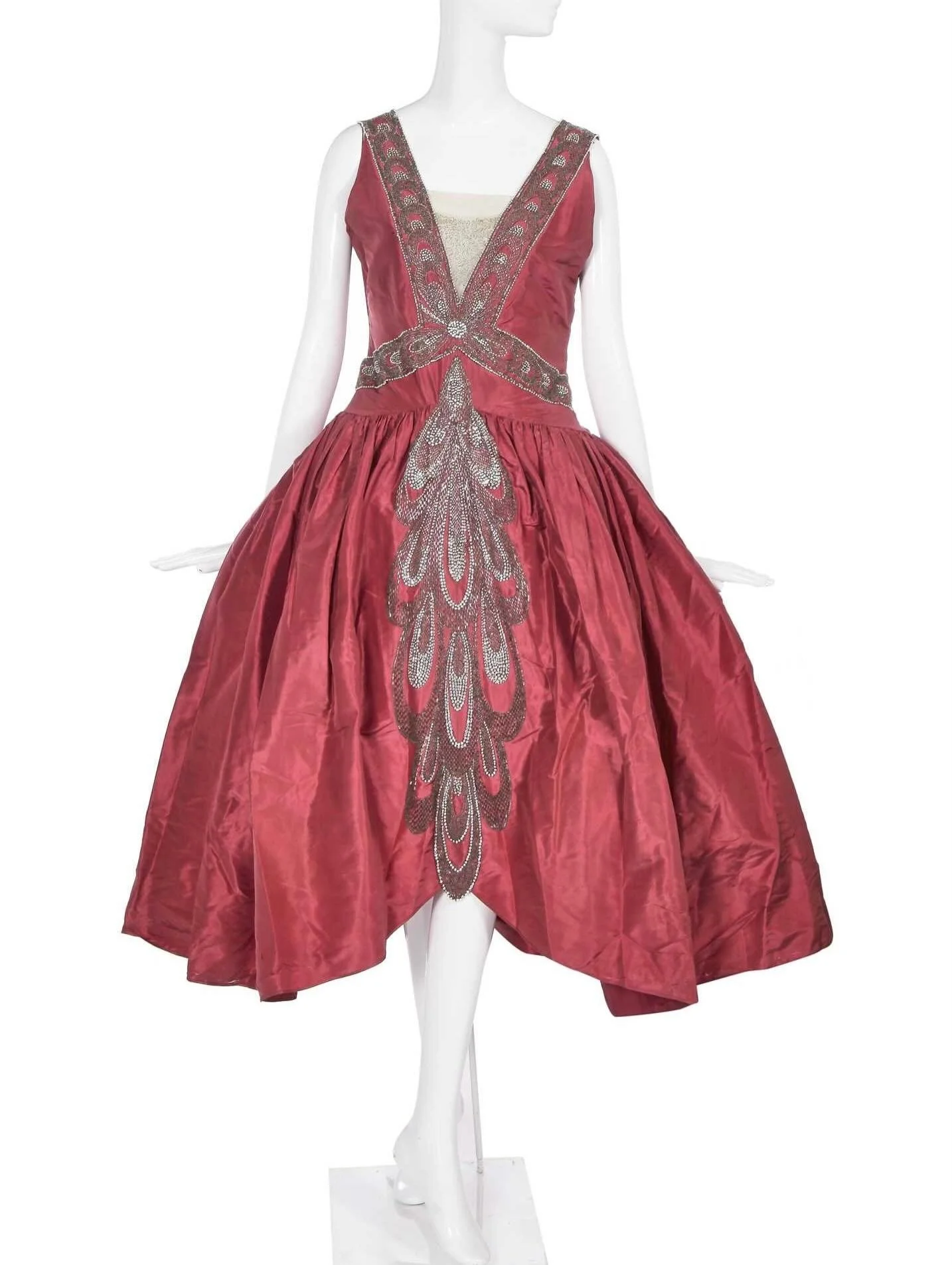 ❣️ &ldquo;raspberry-pink silk taffeta, worked with bands of stylised overlapping peacock feathers in pearl beads, silver bugles and rhinestones forming a large central plume to skirt front&rdquo;

https://www.kerrytaylorauctions.com/auction/lot/lot-5