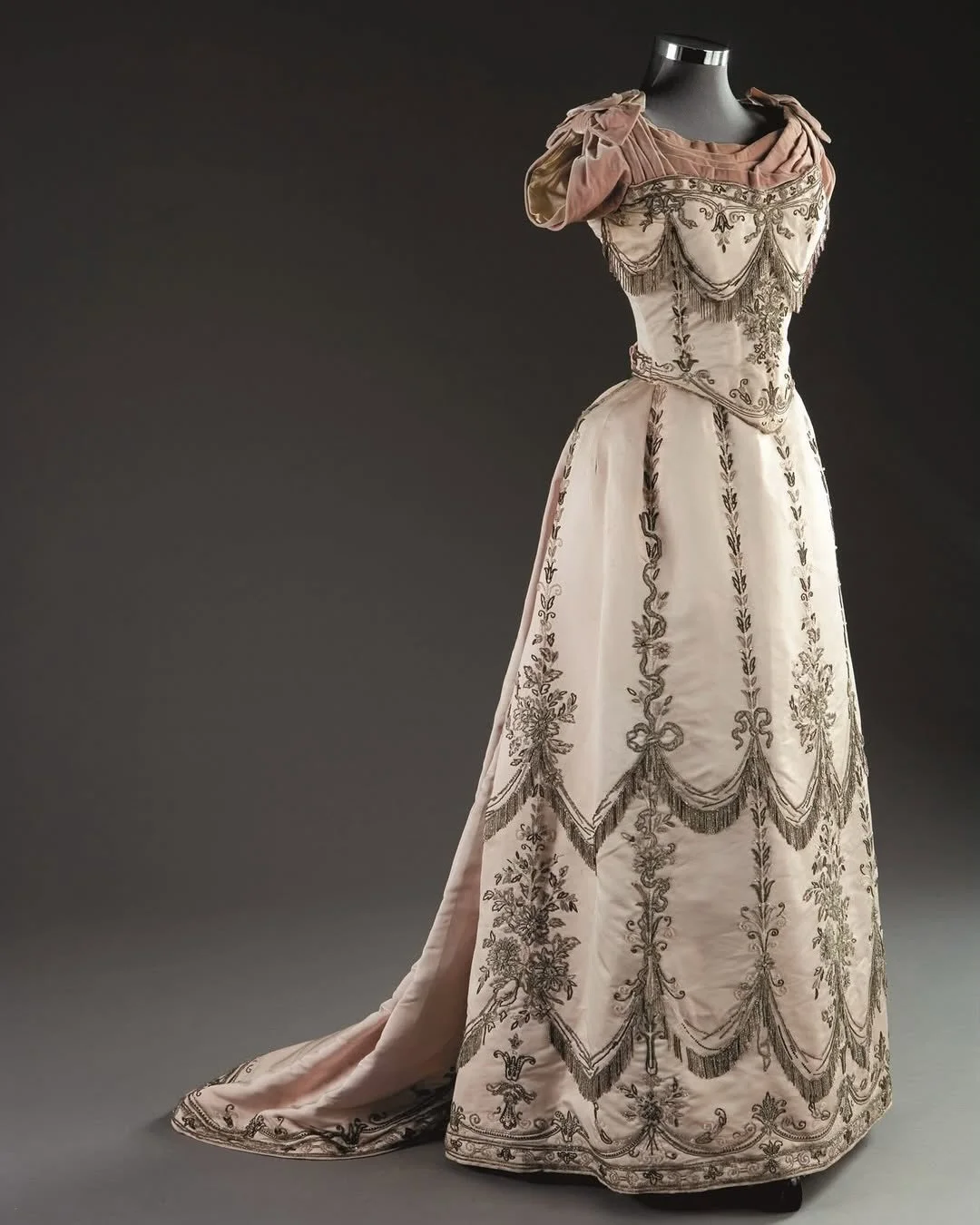 💝 &ldquo;A fine and important Charles Frederick Worth ball gown, 1888, with signature Paris label to bodice waistband, of pale oyster satin edged with pale lilac-grey velvet, the boned bodice back-laced to fasten, with swagged fringes of crystal and