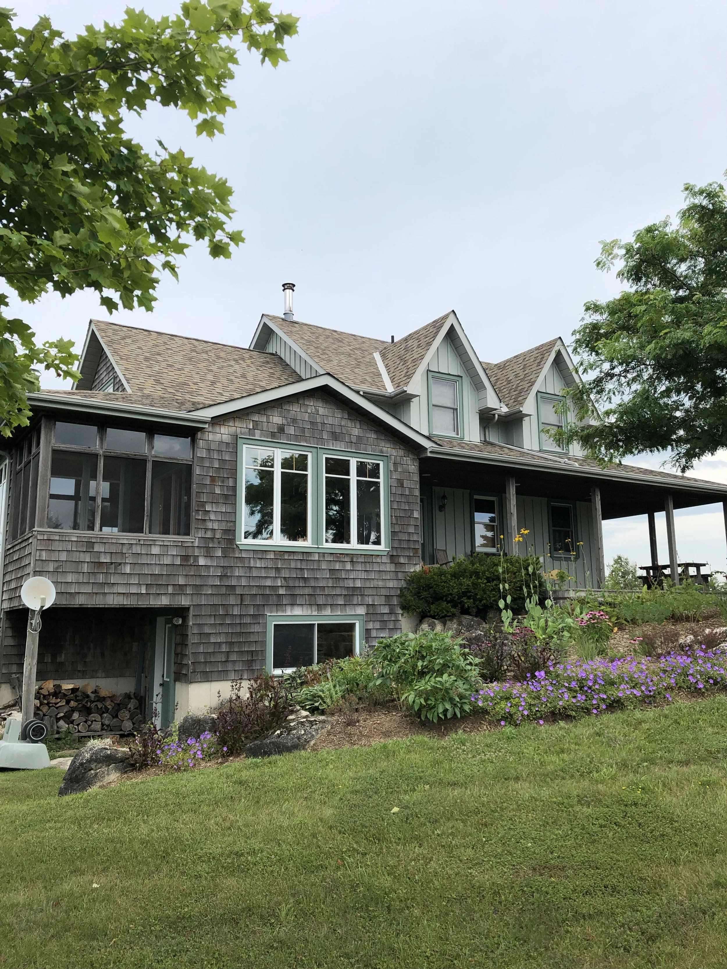 cedar-shake-siding-restoration-on-okanagan-home-with-green-trim-and-gardens