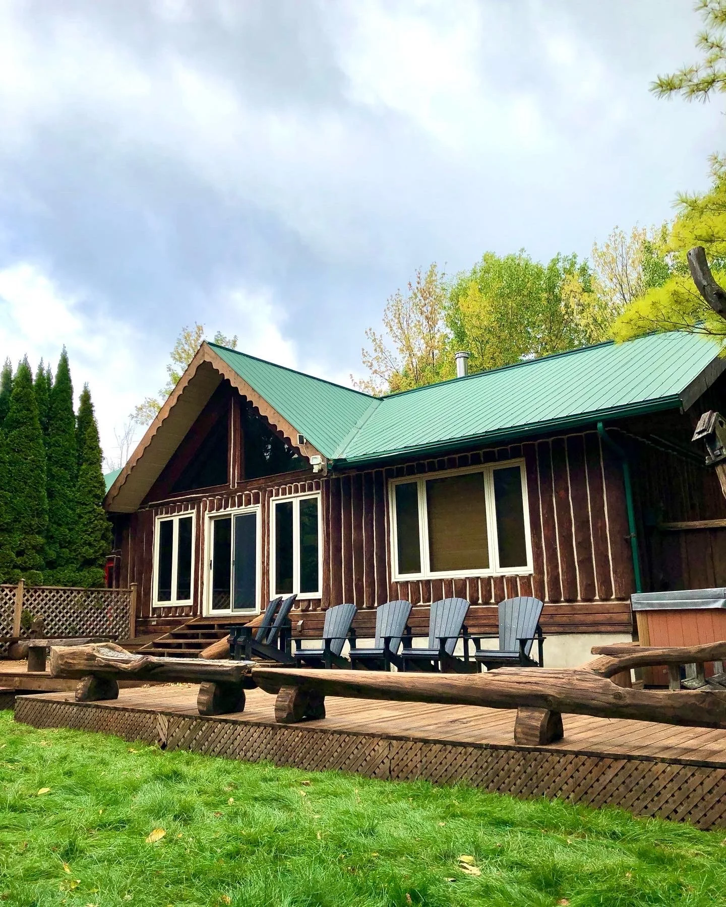 log-cabin-exterior-stain-with-green-metal-roof-on-okanagan-home