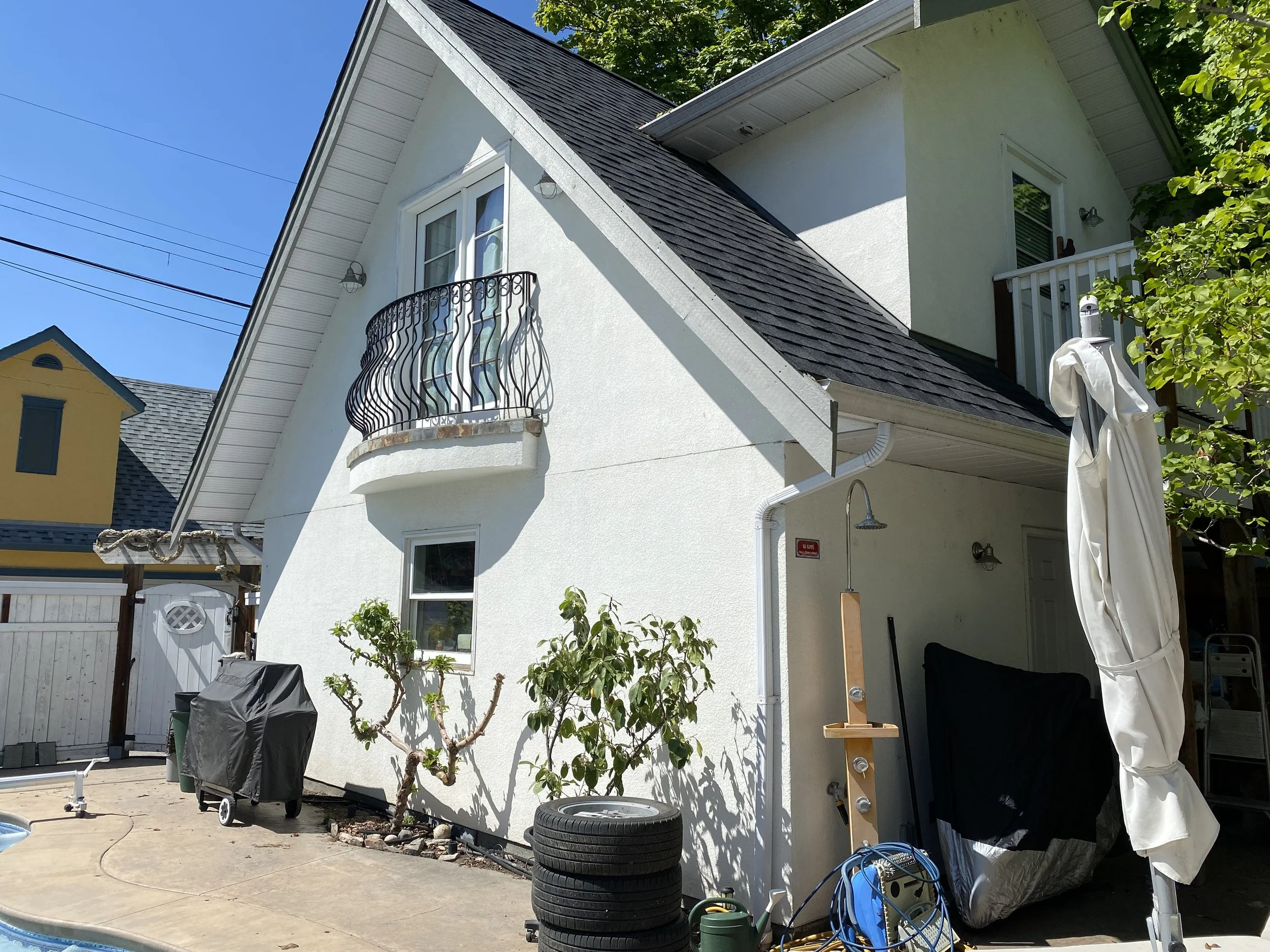 freshly-painted-white-stucco-exterior-on-okanagan-landing-home-with-arched-window