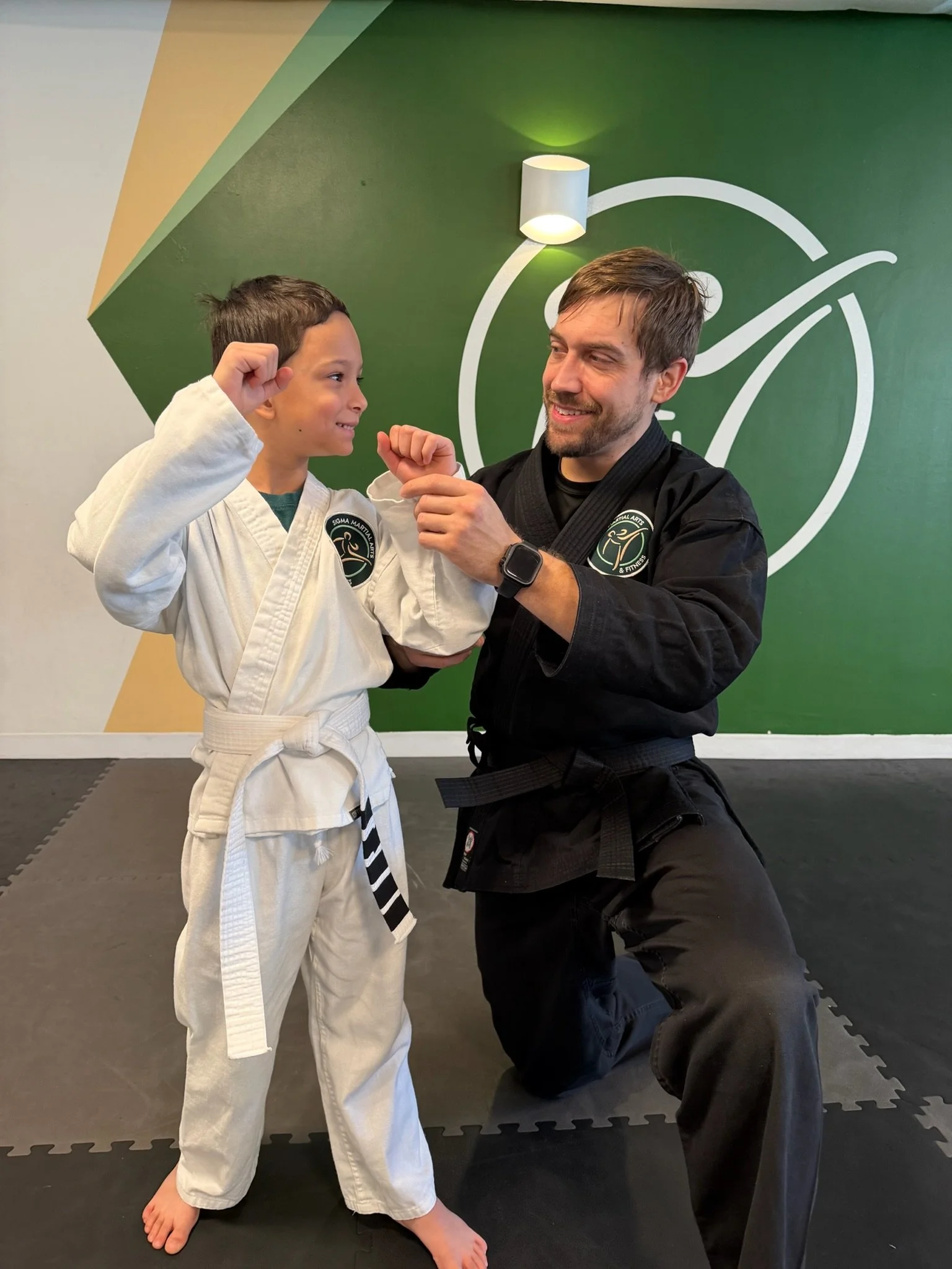 A martial arts instructor helping a student learn a new move