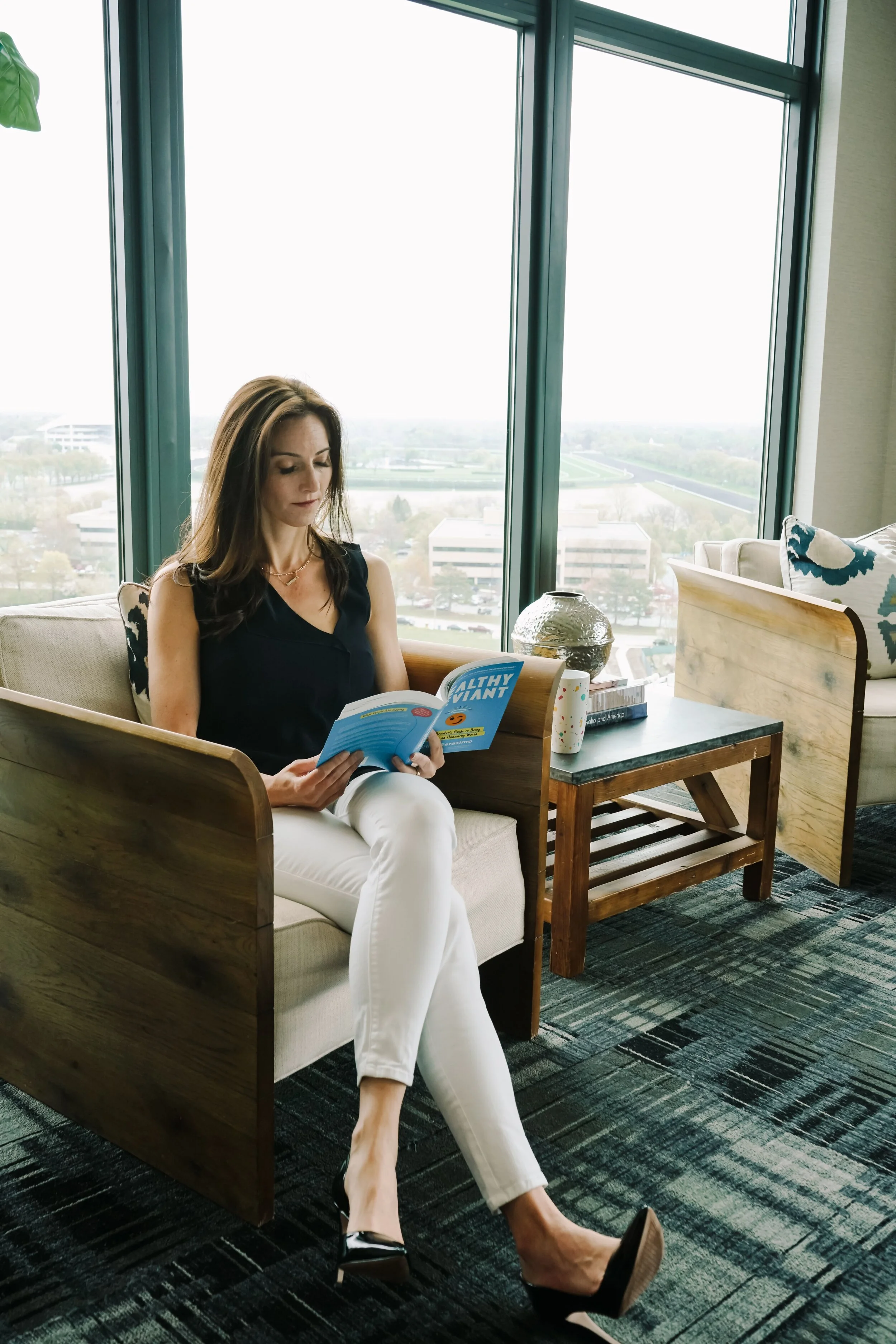 Amanda Hinman sitting in a chair while reading a book
