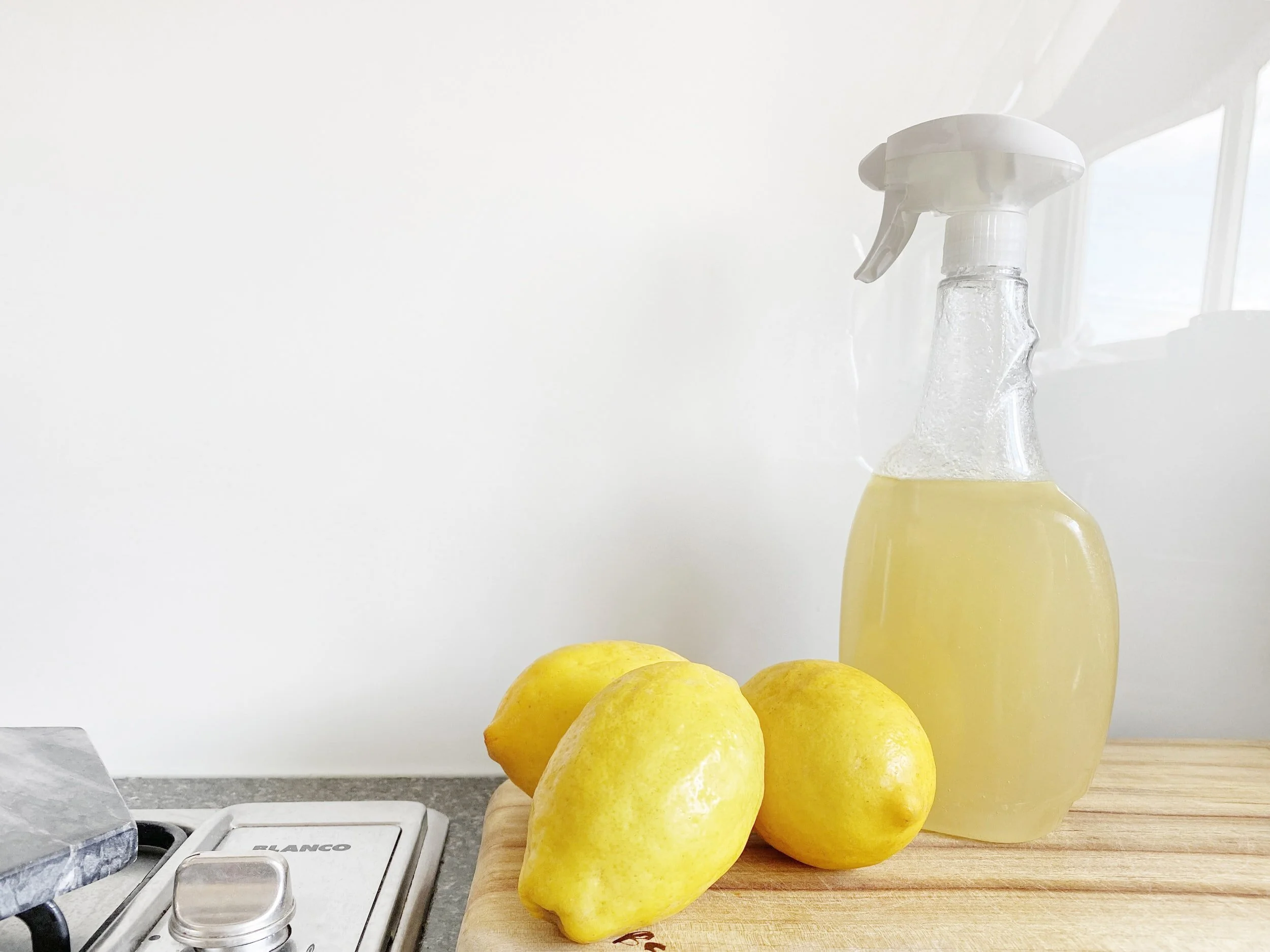 A person spraying mist near a lemon in the kitchen