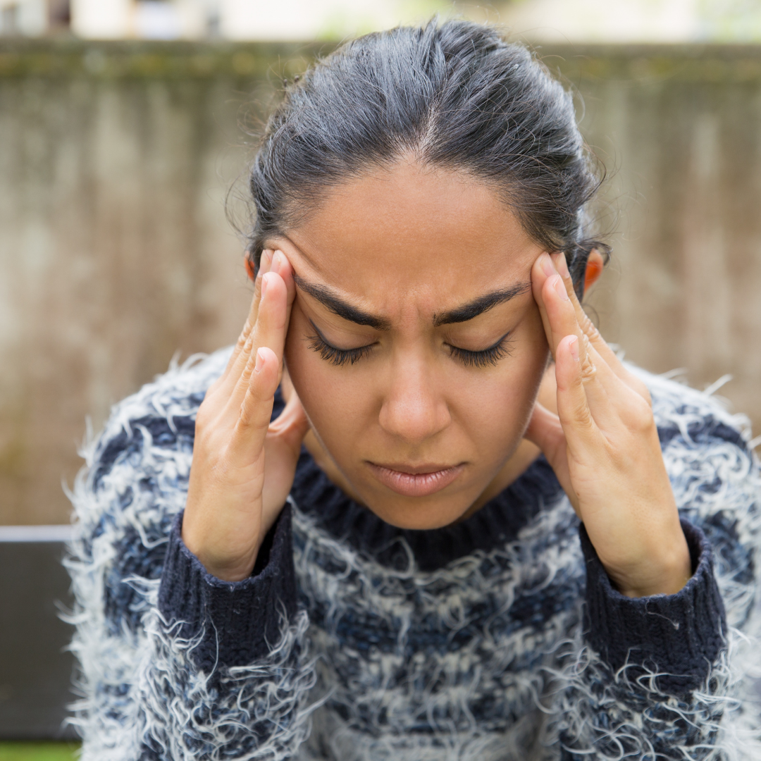 A stressed woman massaging her temples