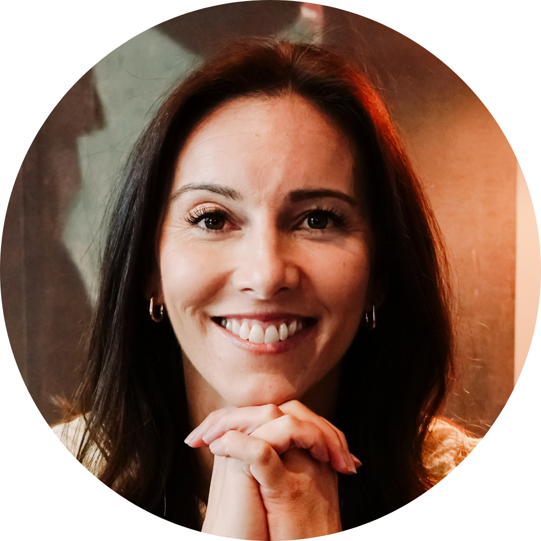 Amanda Hinman sitting on a couch and smiling in a headshot portrait