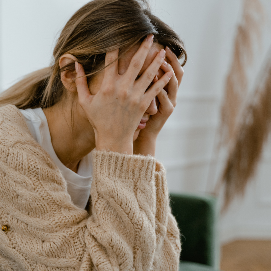A woman touching her face while looking stressed
