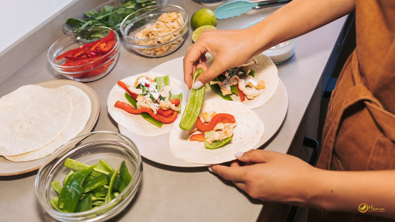 A person preparing a healthy shawarma filled with leafy greens and vegetables