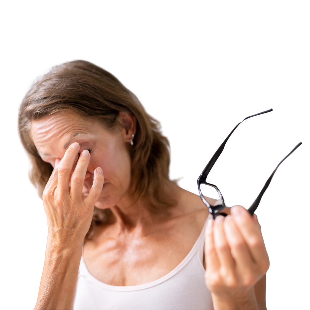 A woman rubbing both eyes with her left hand while holding her eyeglasses