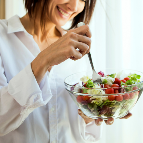 A woman piercing a salad with her fork