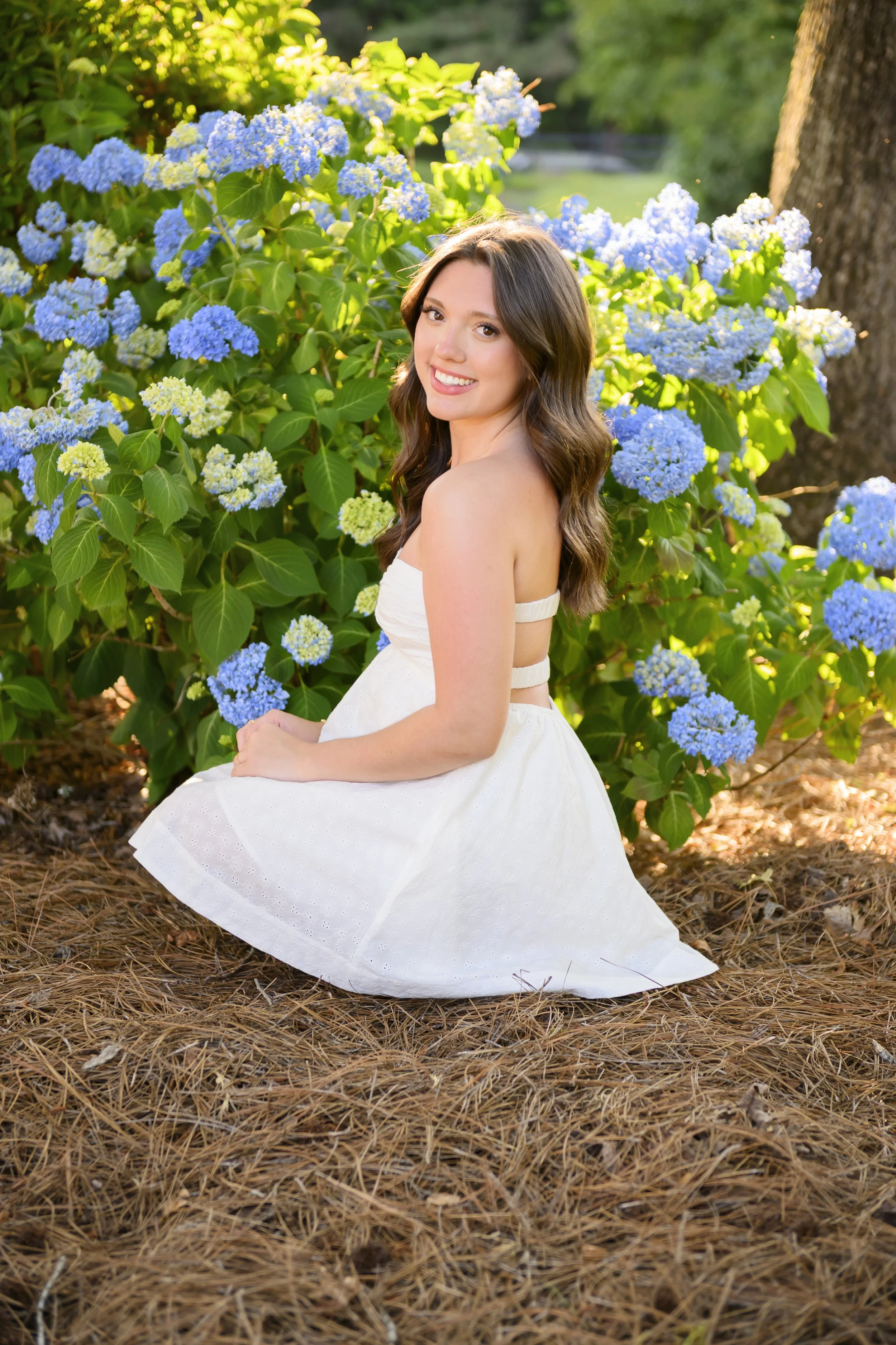 Senior photo with hydrangeas at John B Thomas Gathering Place in Sanford by Jamie Loomis Photography
