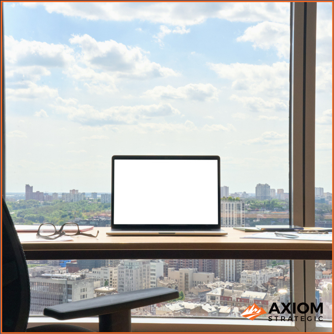 Laptop, notebook, and coffee on a desk by a high-rise window overlooking a city skyline — Grow With Purpose Episode 193.