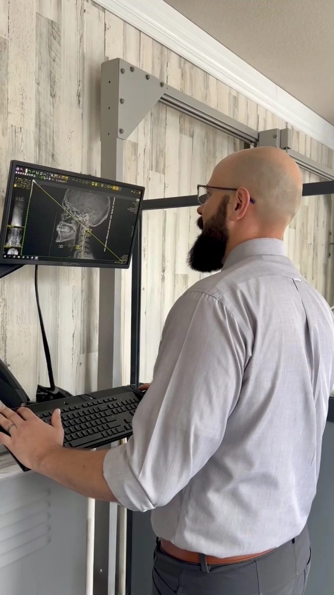 Dr. Reid Bagwell analyzing upper cervical spine X-rays at Be Well Chiropractic in Lakeway, TX