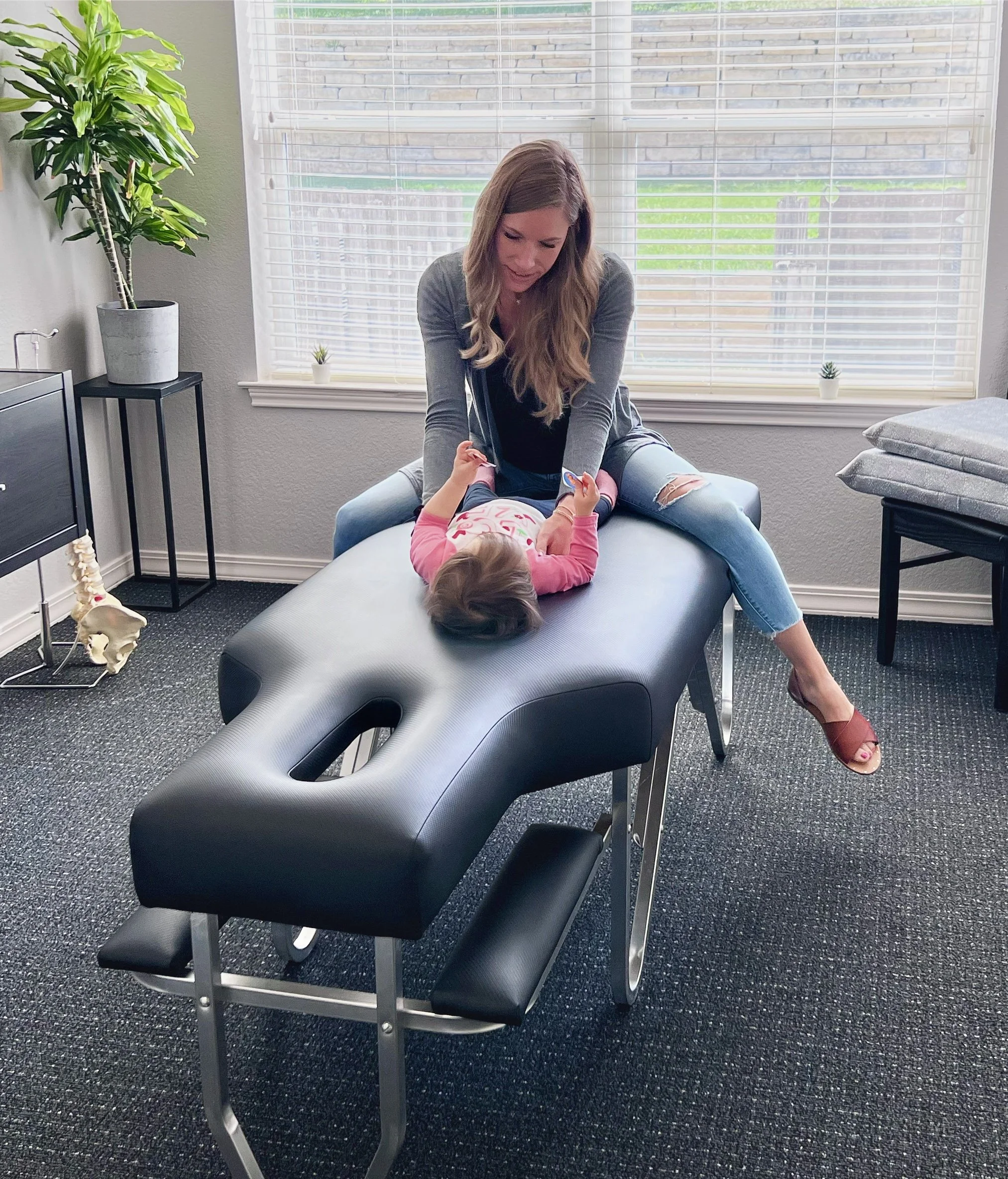 Be Well Chiropractic doctor caring for a young child during a pediatric chiropractic visit in Lakeway, TX