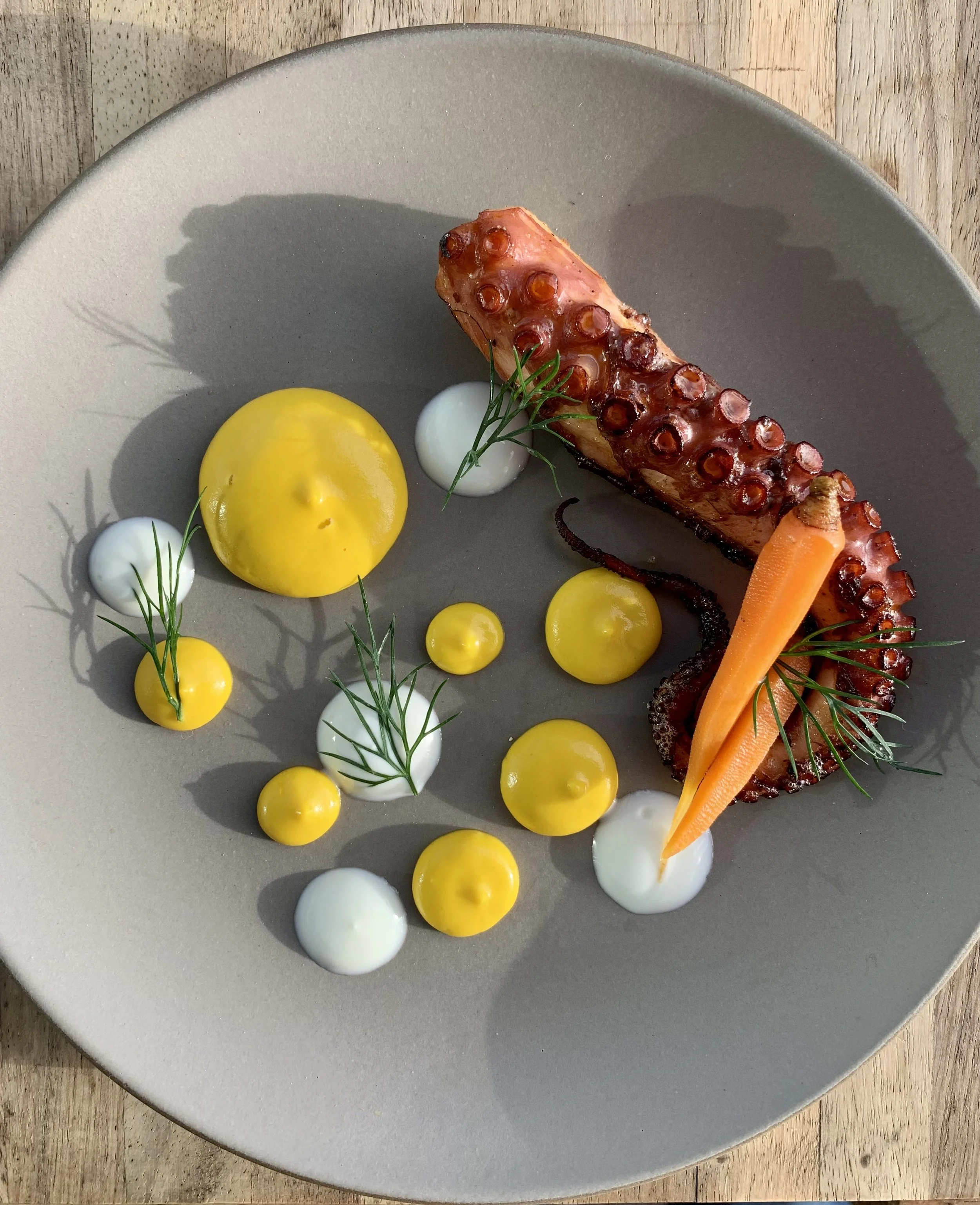 braised and charred octopus served with carrot ginger puree, creme fraiche and pickled onions