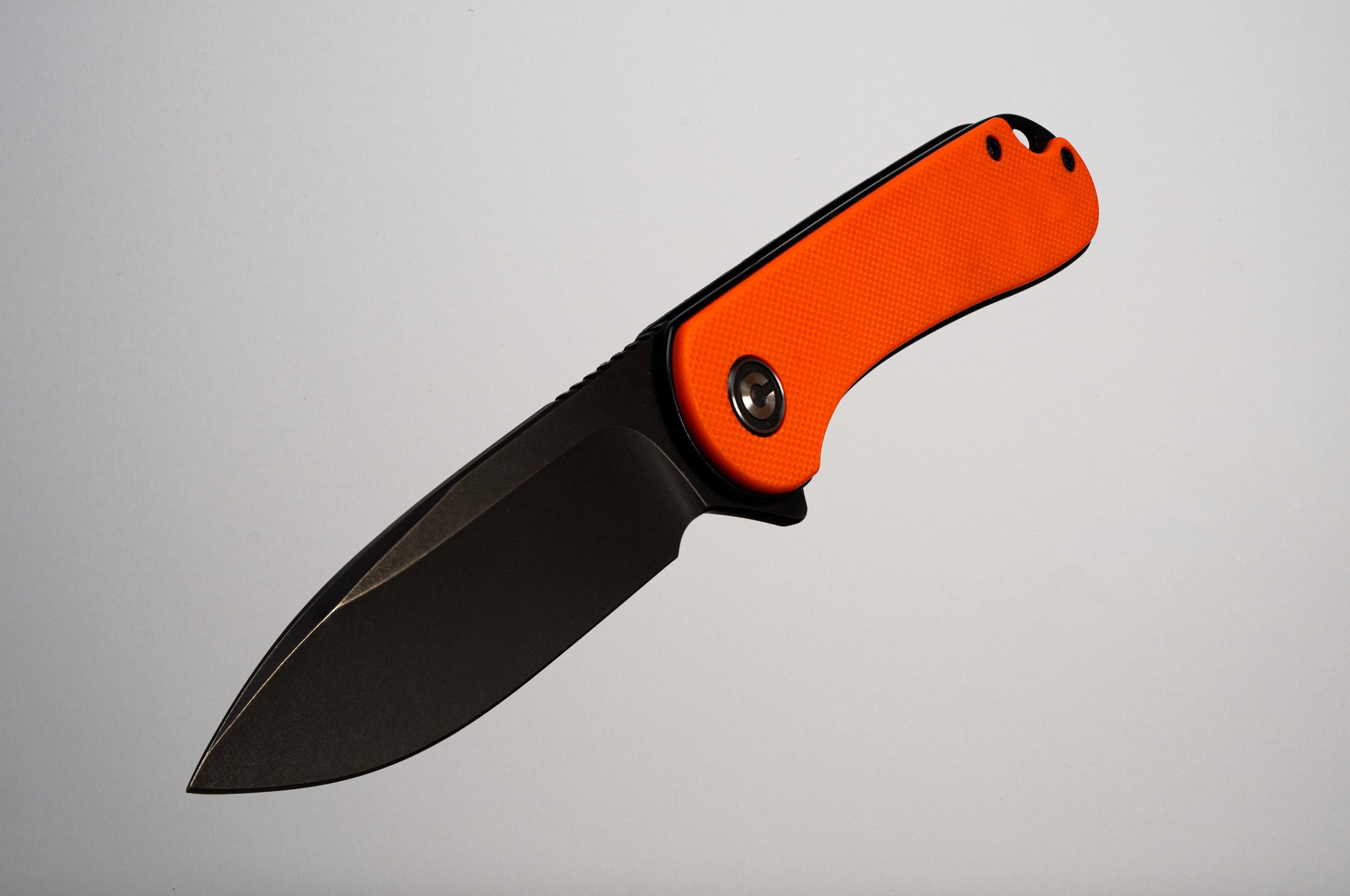 A folding pocket knife with a black blade and an orange handle.