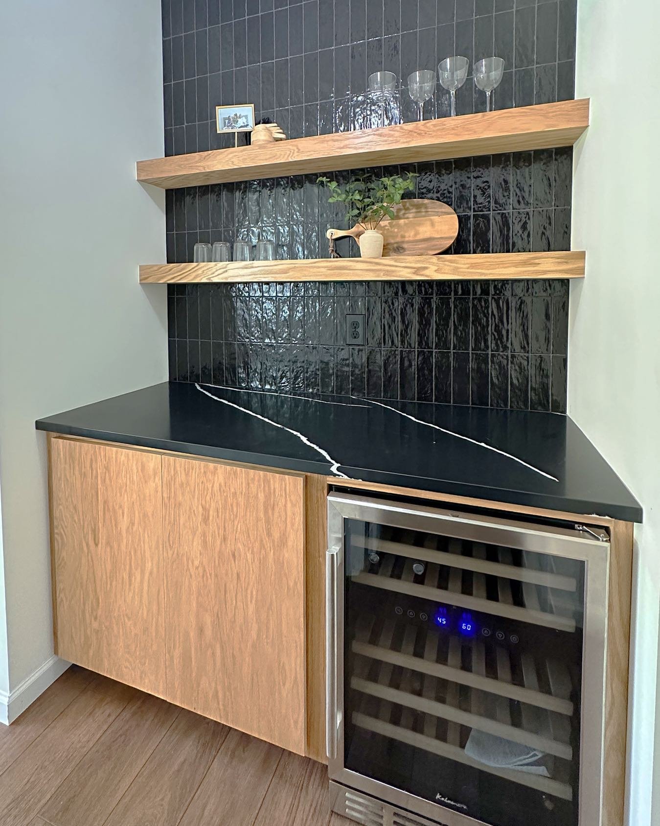 I&rsquo;m loving this dry bar with moody mid-century vibes. 😍 The natural oak of the custom built cabinet and shelves pairs perfectly with the black quartz countertops and tile.

#drybar #winecooler #backsplash #beforeafterhome #beforeafterdesign #r