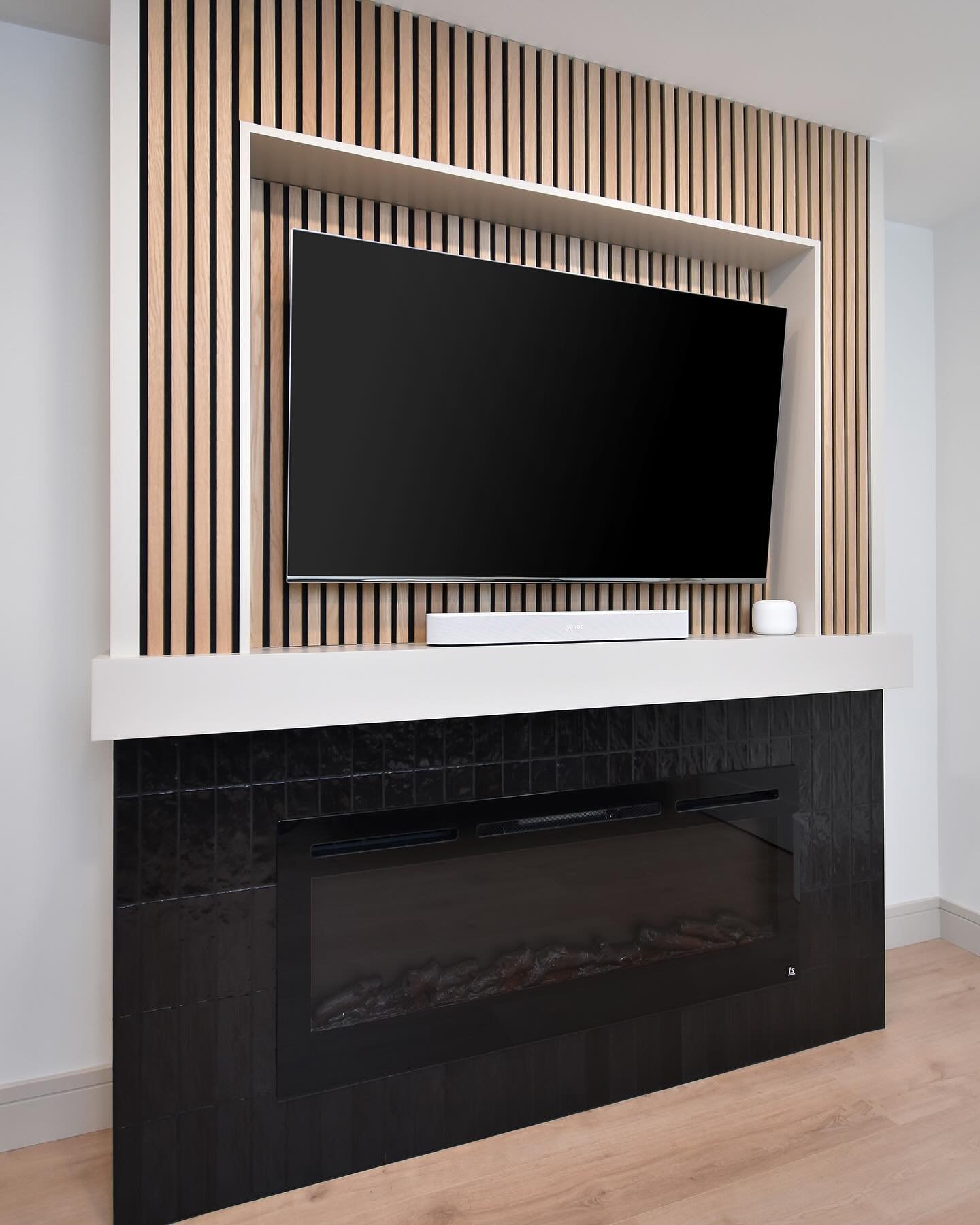 This contemporary built-in entertainment center was one of my last projects in our old house. We went for a high contrast look with the bottom electric fireplace black zellige tile surround, and the top accented with natural oak wood slats from @thew