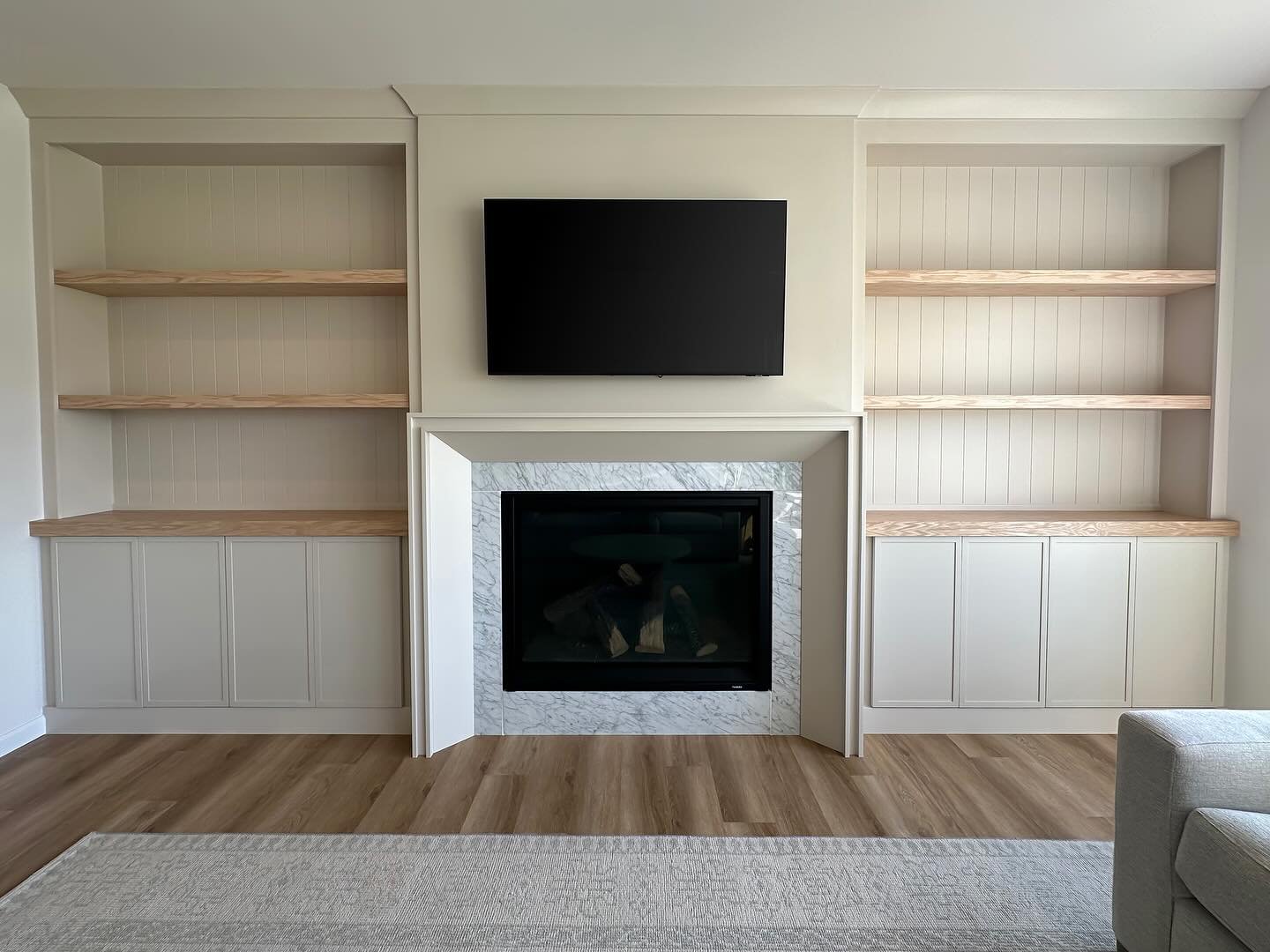 Just wrapped up this stunning built-in bookcase and fireplace surround! This was a particularly fun project with unique design elements. I created a custom cove mantle around the existing stone, paired with natural oak shelves and countertop, and add