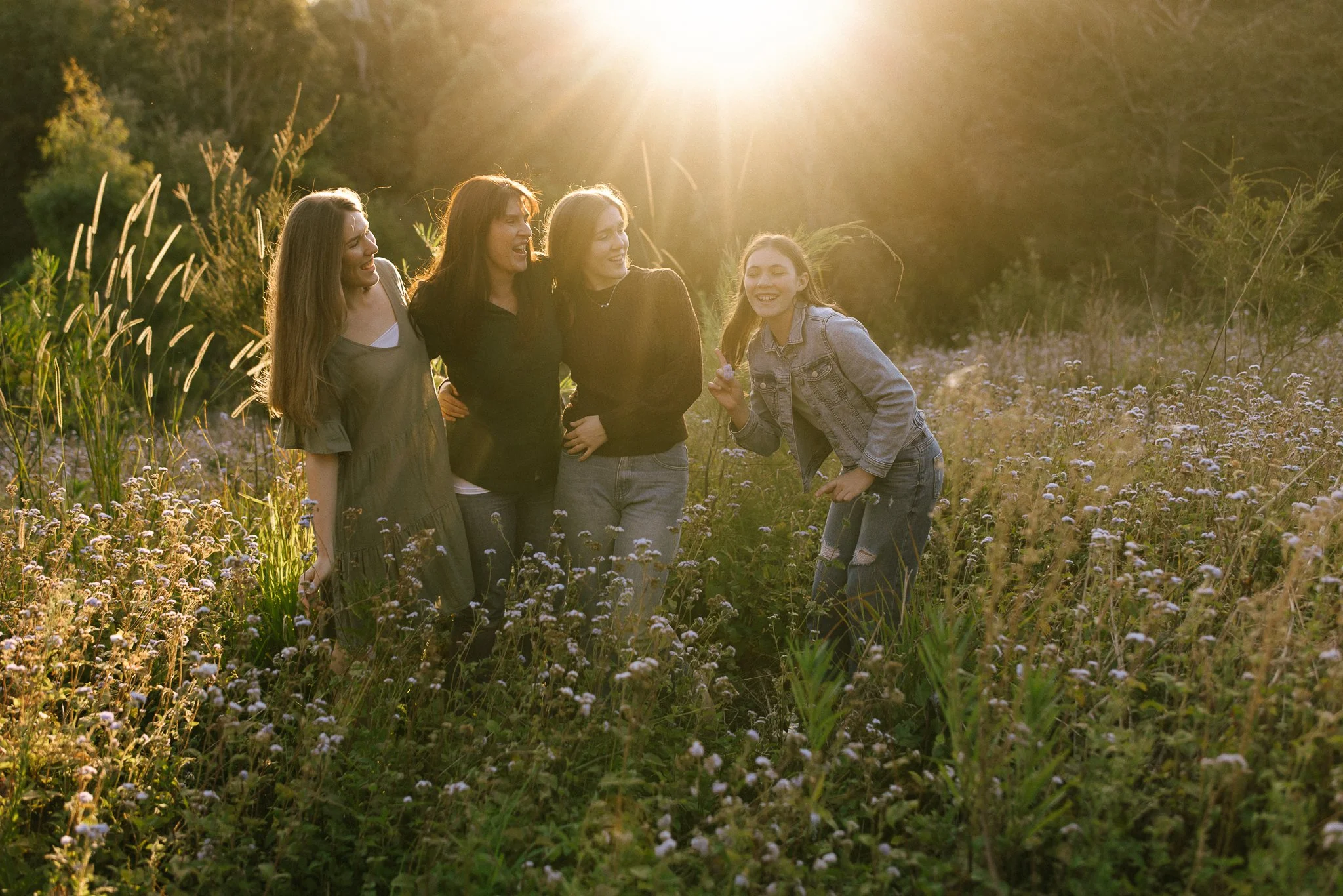 Gold Coast family photographer capturing a warm golden hour family session in a wildflower field