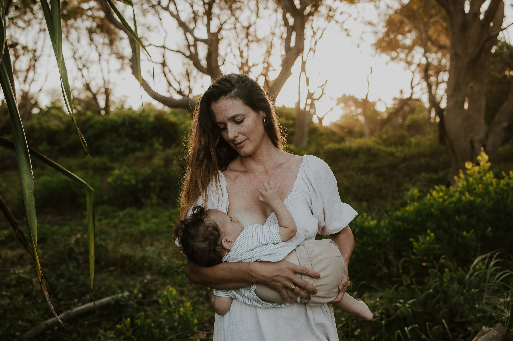 young mother nursing her child in beautiful jungle setting Northern rivers