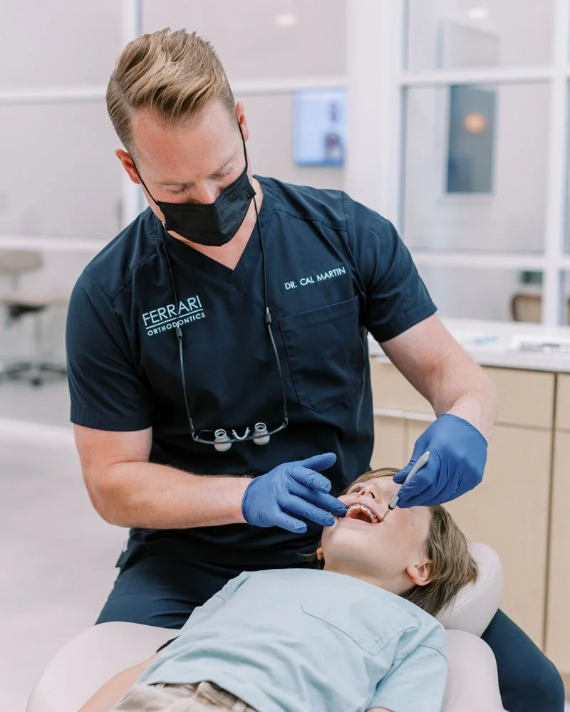 Orthodontist performing a dental checkup on a young boy in a dental office.