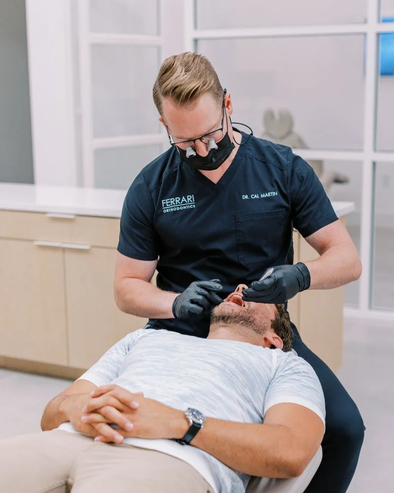 Orthodontist performing oral dental work on a patient in a dental office.