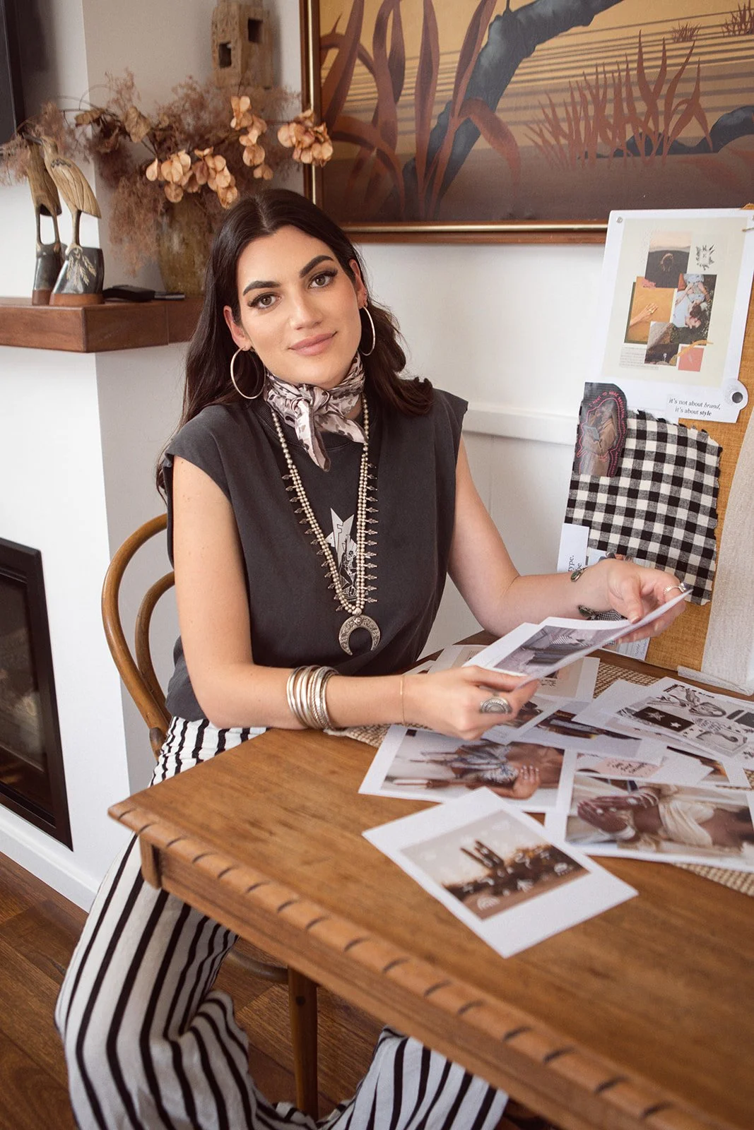 photo of rebecca achelles smith sitting at desk assembling paper on a moodboard