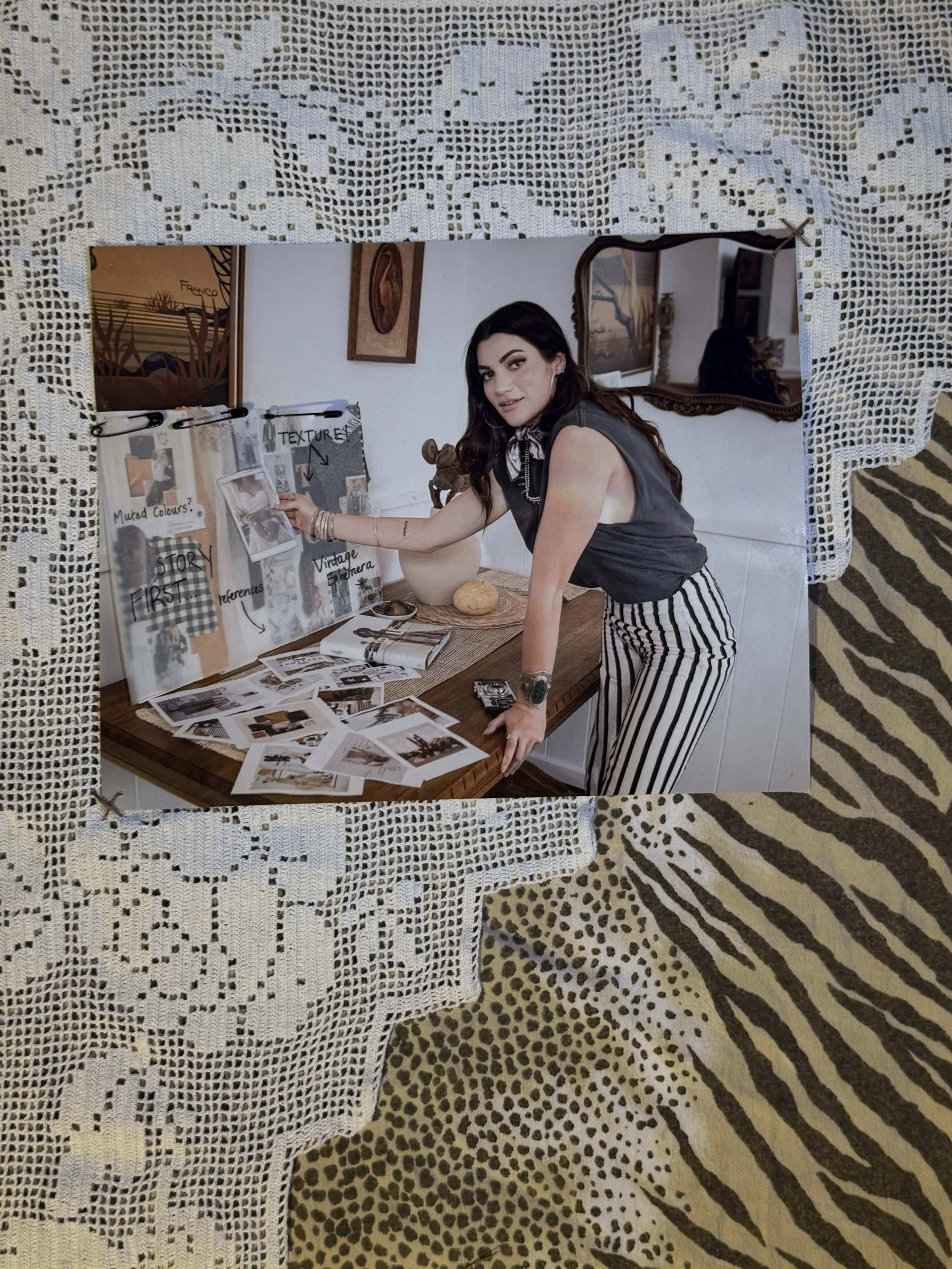 Photo of Rebecca (Achelles) Smith with a mood board wearing black and cream linen stripe pants and a muscle tshirt.