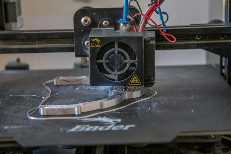 A desktop 3D printer building a part layer by layer.