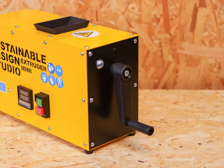 Extruder Mini V2 being hand-cranked at the bench