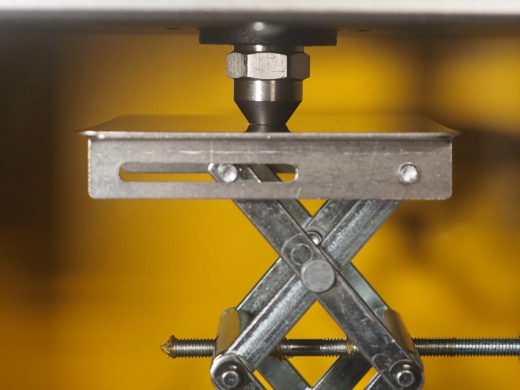 Close-up view of a metal scissor jack, showing its components and mechanisms.