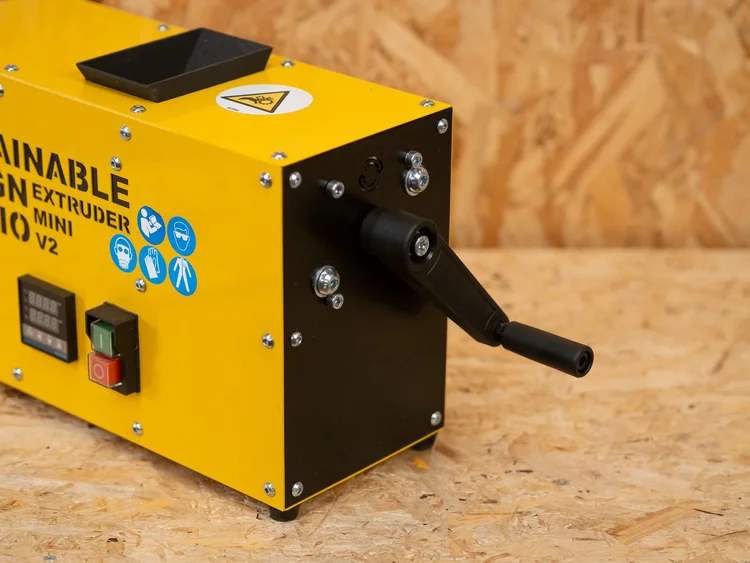 Extruder Mini V2 being hand-cranked at the bench