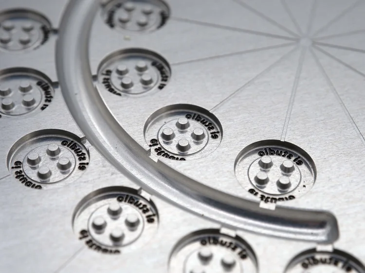 Custom-engraved button moulded from recycled plastic