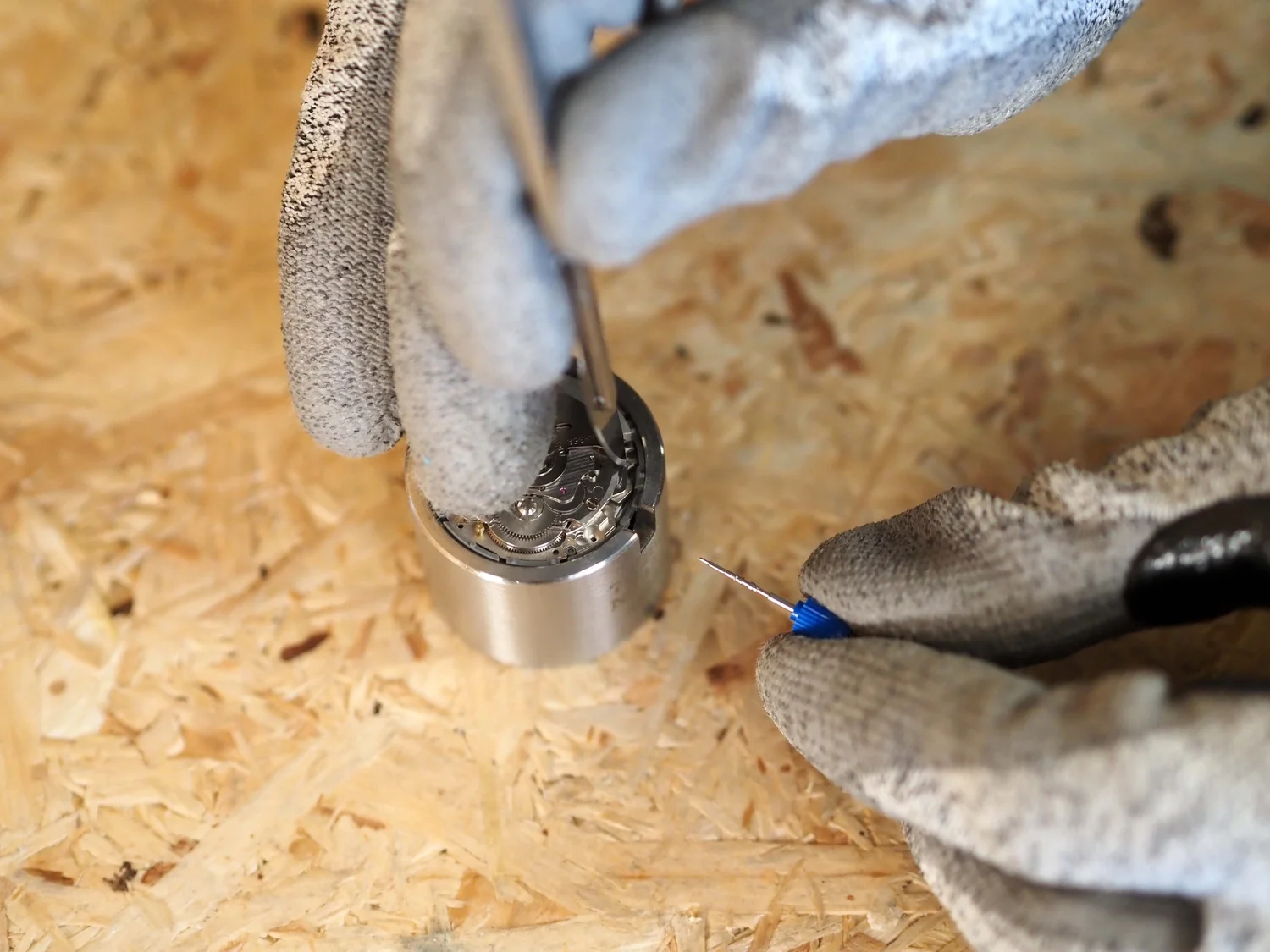 Stem release lever pressed on the NH35 movement to allow stem removal.