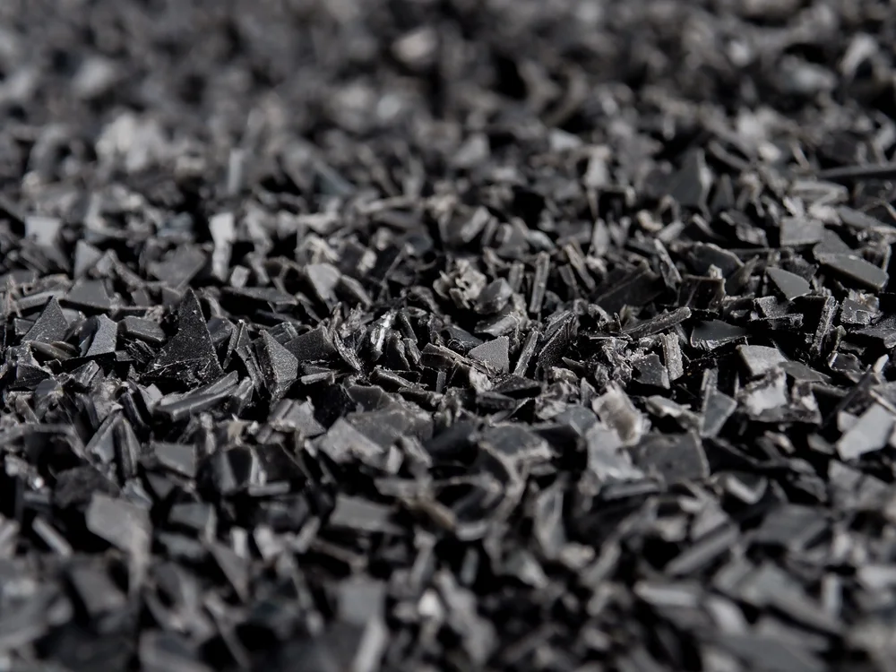 A workshop shreds sorted plastic into clean flake, the saleable feedstock produced at Stage 2.