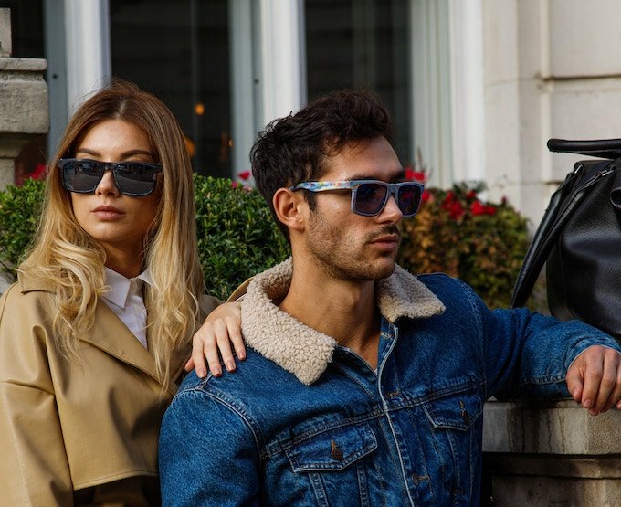 Male and female model wear recycled sunglasses.