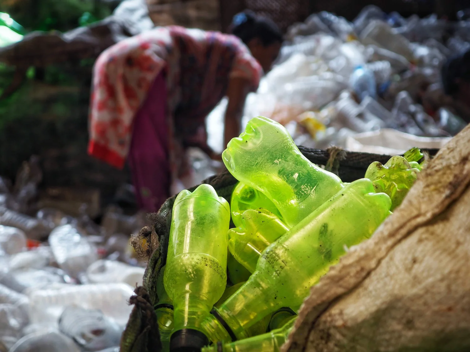 A worker sorts plastic bottles by polymer and colour at a recycling yard in Bangladesh, Stage 1 of the value ladder.