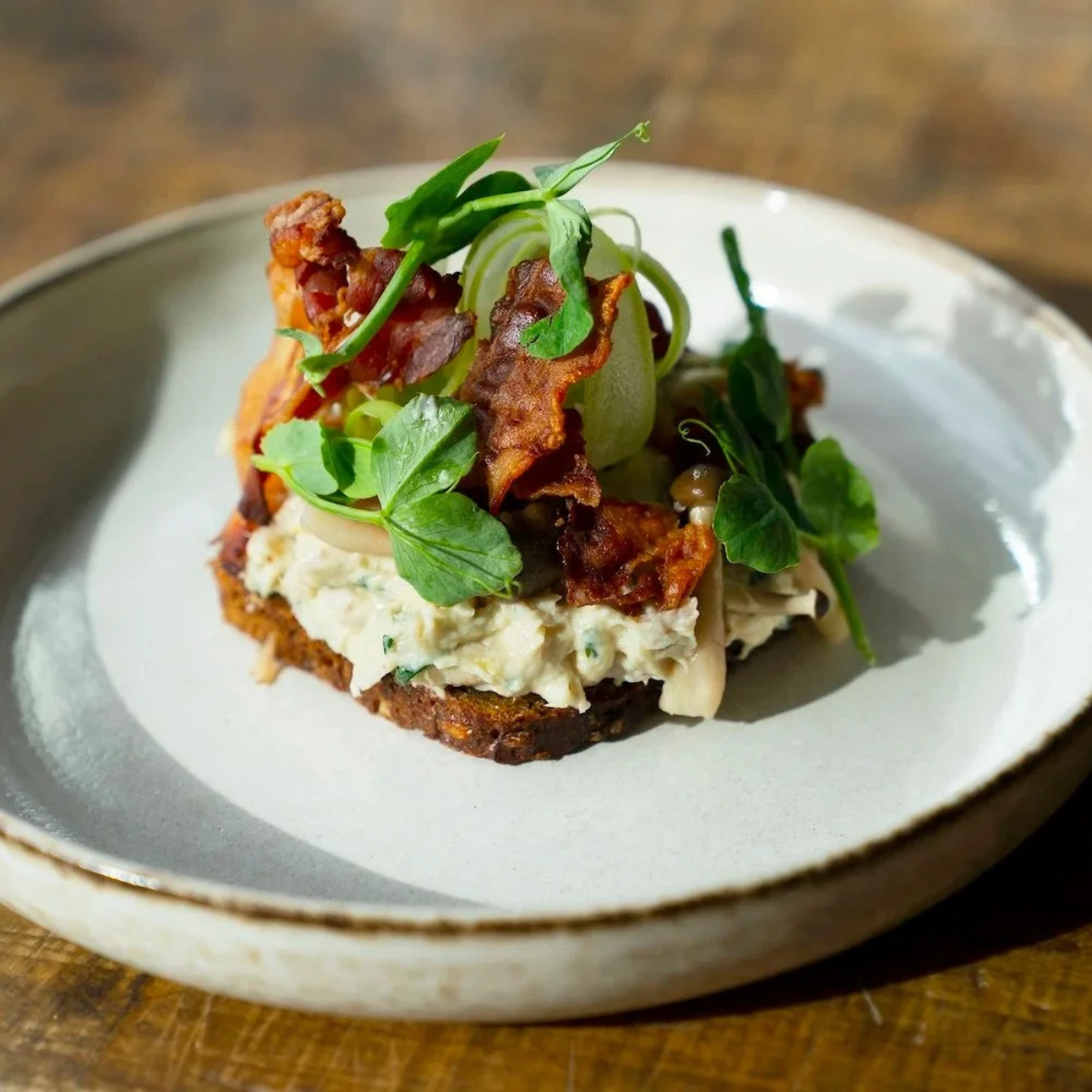 Danish smorrebrod with chicken salad, crispy bacon and pea shoots at Fleisch in Vesterbro.