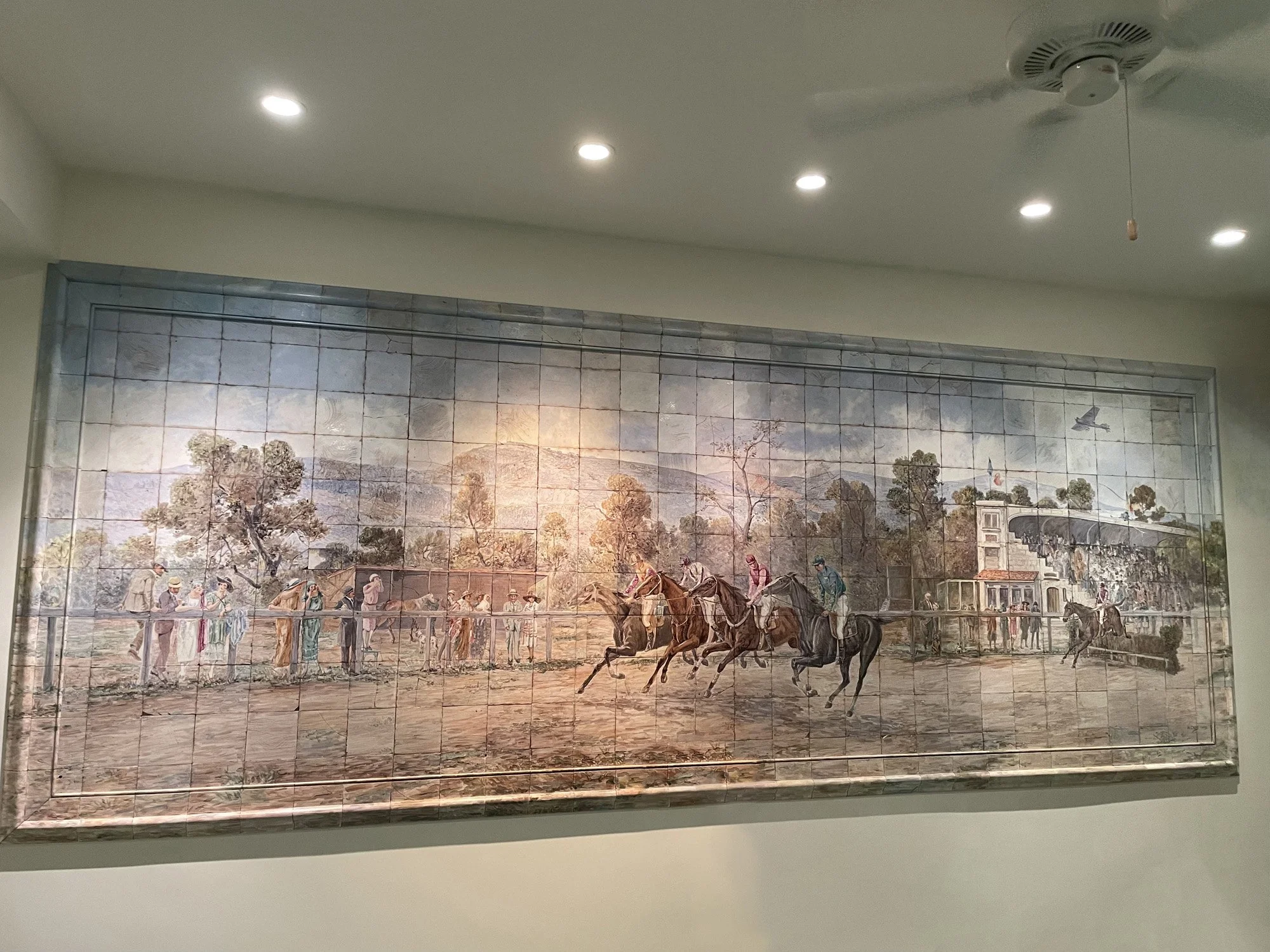 The Hippodrome - The tile wall in the gym is hand painted with the legendary Côte d’Azur Racecourse near Cannes and Nice. If you look closely, you will notice both the current and previous owners of the farm have been painted into the piece.