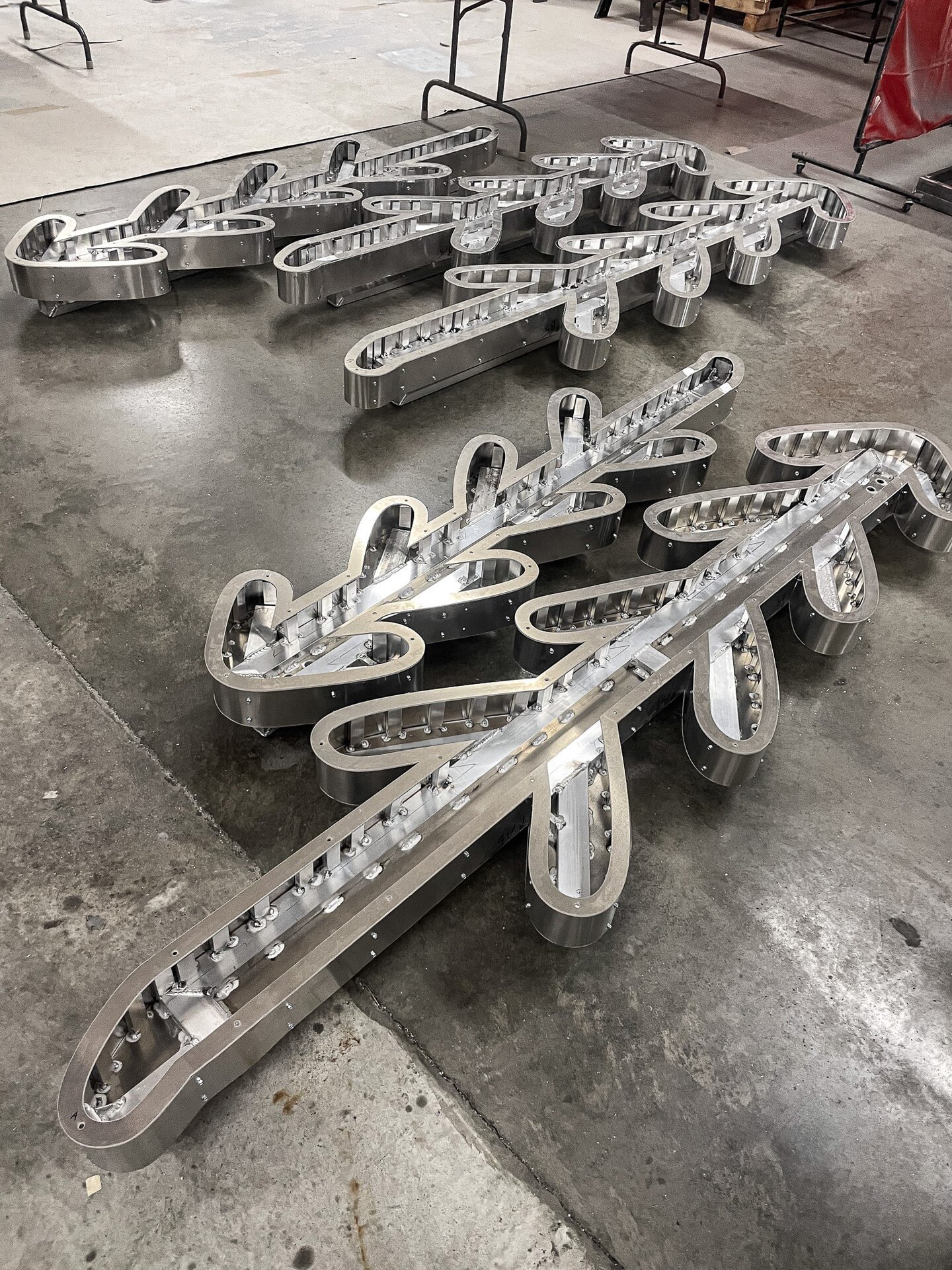 This was quite the aluminum project in metalworking! Working structure into an organic logo was challenging, but these looked so cool before paint.