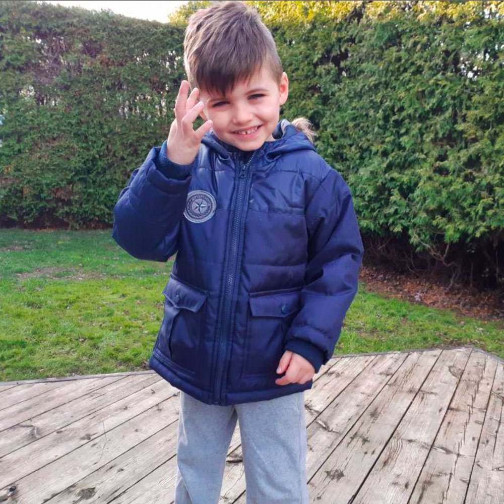 Liam smiling outside on a deck in a backyard