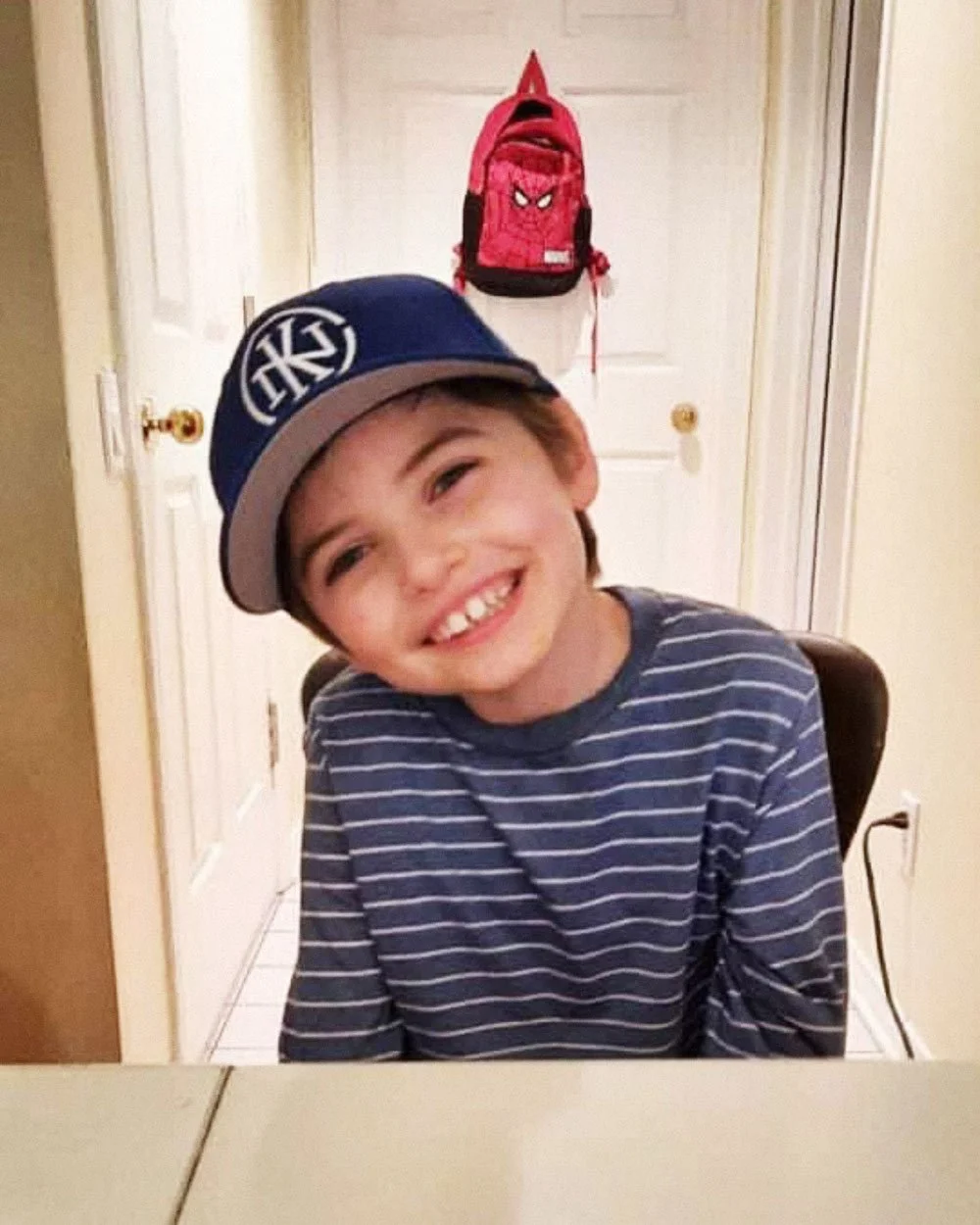 Liam grinning and wearing a Knuckles Nilan cap