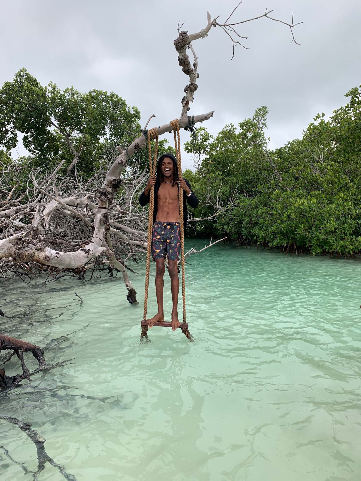 A man standing on a swing in the backcountry of Key West during a Salty Soul Boat Charter.