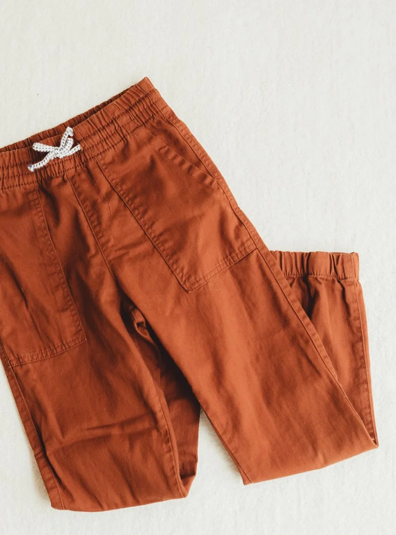 Brown cargo pants with an elastic waistband and a white drawstring, laid flat on a white surface.
