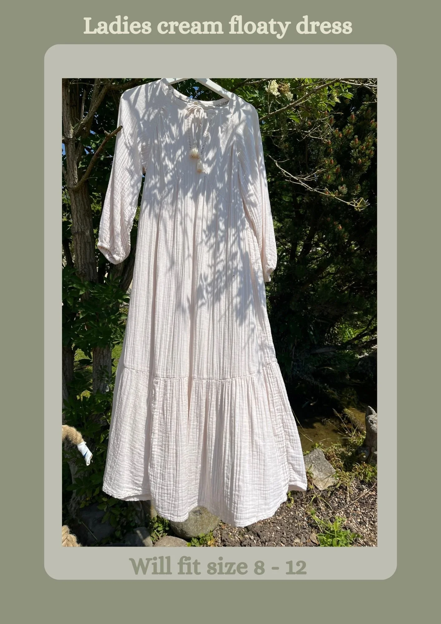 A white ladies floaty dress hanging outdoors, surrounded by trees and greenery, with text indicating it fits size 8 to 12.
