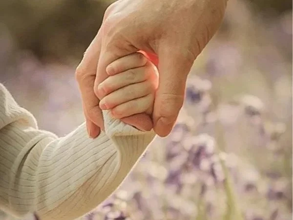 mother and child holding hands in the bluebells