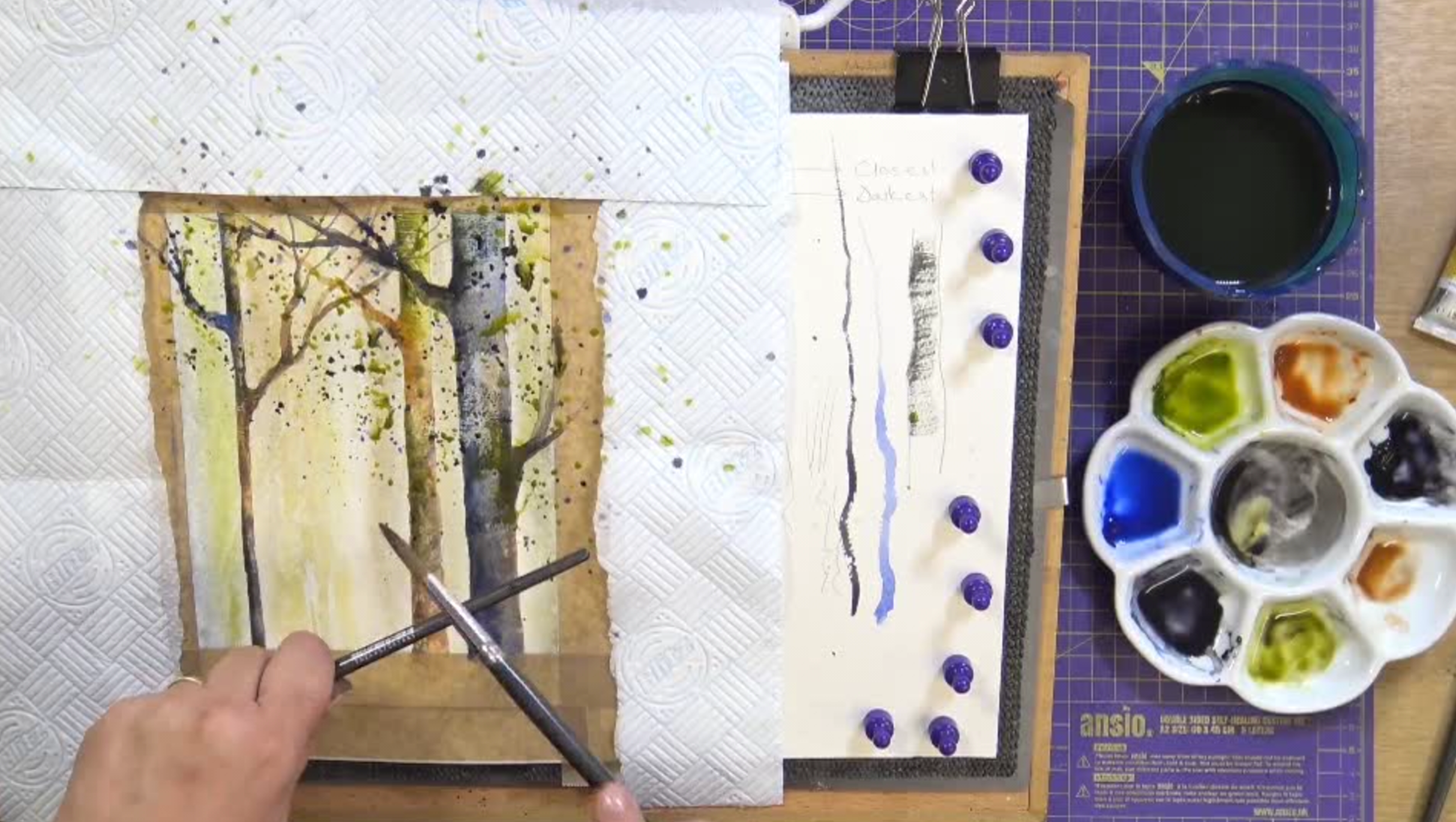 Watercolor painting of trees with art supplies