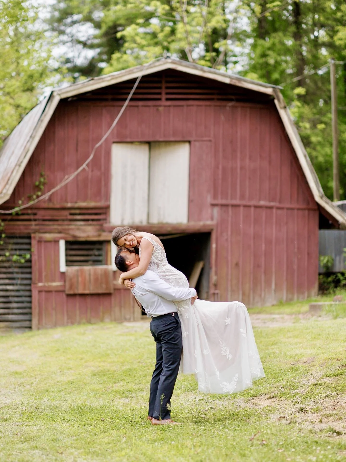 Couple kissing in front of the red barn at Thornhill Farm in Hendersonville, NC