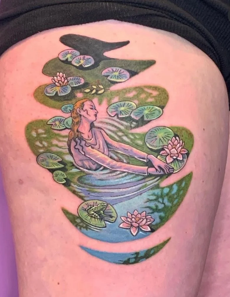 Tattoo of a woman with long hair swimming in a pond with lily pads, lotus flowers, and a frog.
